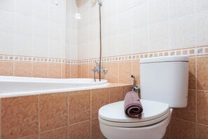 A bathroom with a bathtub, toilet, and shower. - Simply 1BR Grand Palace Kemayoran Apartment (Jakarta)