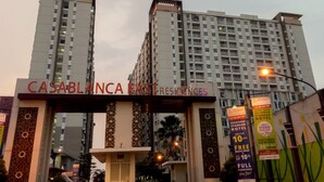 A high-rise building with a sign reading "CASABLANCA EAST RESIDENCES". - Minimalist with City View 2BR Apartment at Casablanca East Residences (Jakarta)