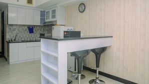 Une cuisine moderne avec des meubles blancs, un pare-feu en carrelage et un mur en bois.