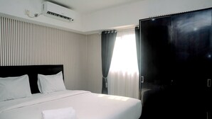 Une chambre d’hôtel avec un grand lit, une armoire et une fenêtre avec des rideaux.