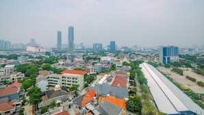 A cityscape with a mix of residential and commercial buildings, including a prominent high-rise. - Relaxing and Stylish Studio at Amethyst Tower Apartment (Jakarta)