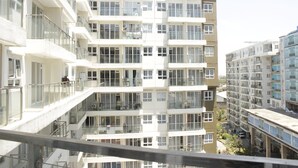 A multi-story residential building with balconies, large windows, and a modern architectural design.