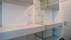 A modern, minimalist room with white walls and a glass partition. - Modern Furnished @ 1BR Margonda Residence 1 Apartment (Depok)