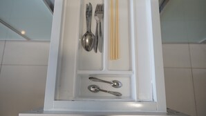 A drawer with utensils including a spoon, fork, knife, chopsticks, and a pair of chopsticks. - Elegant Studio Parkland Avenue Apartment (South Tangerang)