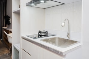 Kamer | Privékeuken | Een koelkast, een kookplaat, kookgerei, borden en bestek