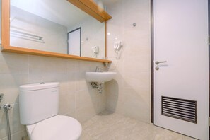 Un baño con inodoro, lavabo y espejo.