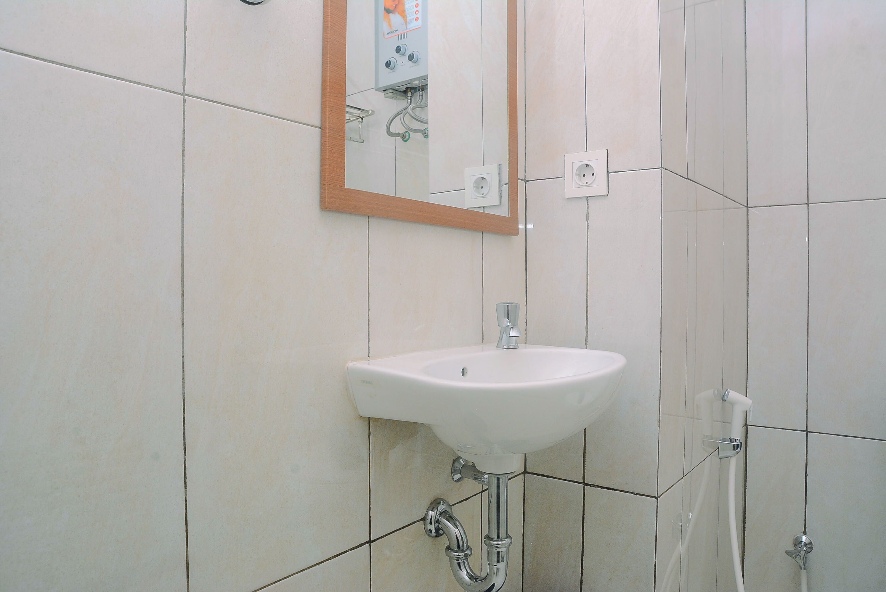 A bathroom with a white sink, a mirror, and a shower.