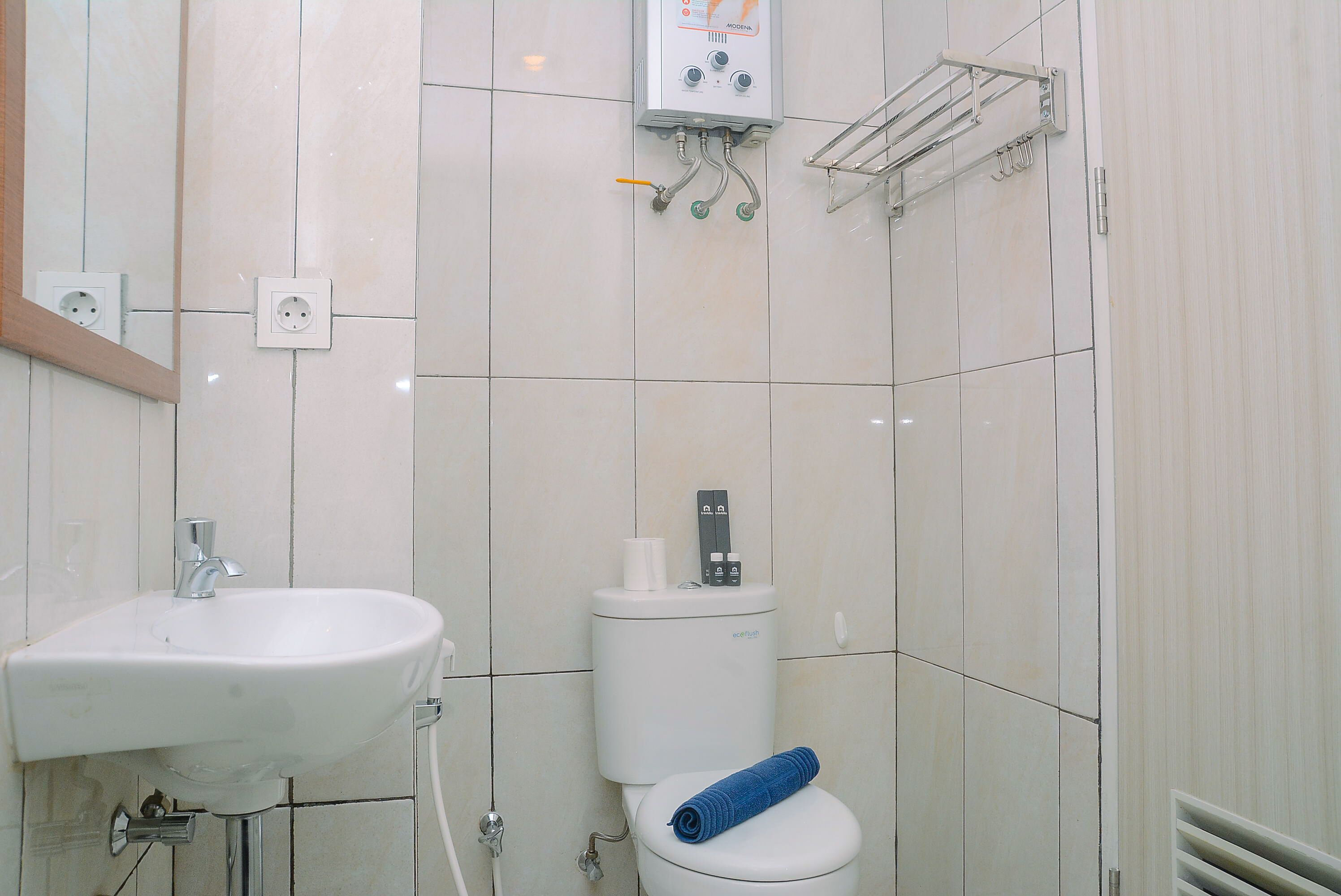 A bathroom with a white sink, toilet, and shower.
