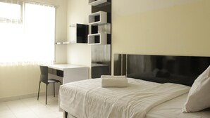 A modern bedroom with a bed, a desk, and built-in shelving.