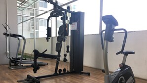 A gym with exercise equipment including a treadmill, elliptical, and multi-gym machine.
