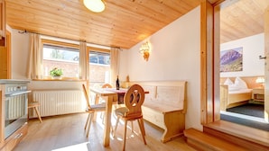 Een houten interieur met een keuken, een eethoek en een bed.