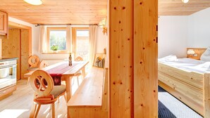 Een houten interieur met een eetgedeelte, een keuken en een slaapkamer.