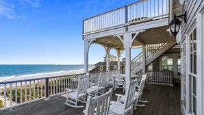 A wooden deck with white rocking chairs overlooking the ocean. - Frankly My Dear - Duck, Oceanfront, Elevator, Wheelchair Friendly, Pool, Hot Tub, Flex Stays (Duck)