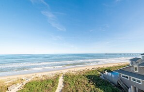 Enjoy stunning ocean views from the comfort of this beachfront property, featuring a lawn, pathway to the beach, and a swimming pool.