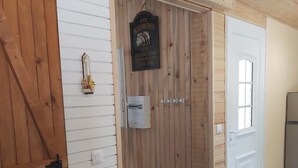 A wooden interior with a door labeled "The Blue Dolphin Inn" and a small sign above it. - Le gîte du Pic-vert in the woods of Périgord Pourpre (Saint-Pierre-d'Eyraud)