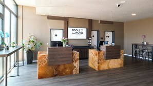 A hotel reception area with marble counters, a large sign reading "TOOLS HOTEL," and a seating area with bar stools. - Tools Hotel Laichingen/Ulm (Laichingen)