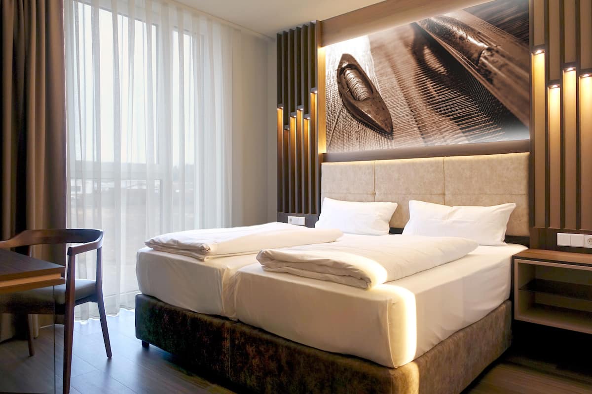 Une chambre d’hôtel avec un grand lit, un bureau et une chaise.
