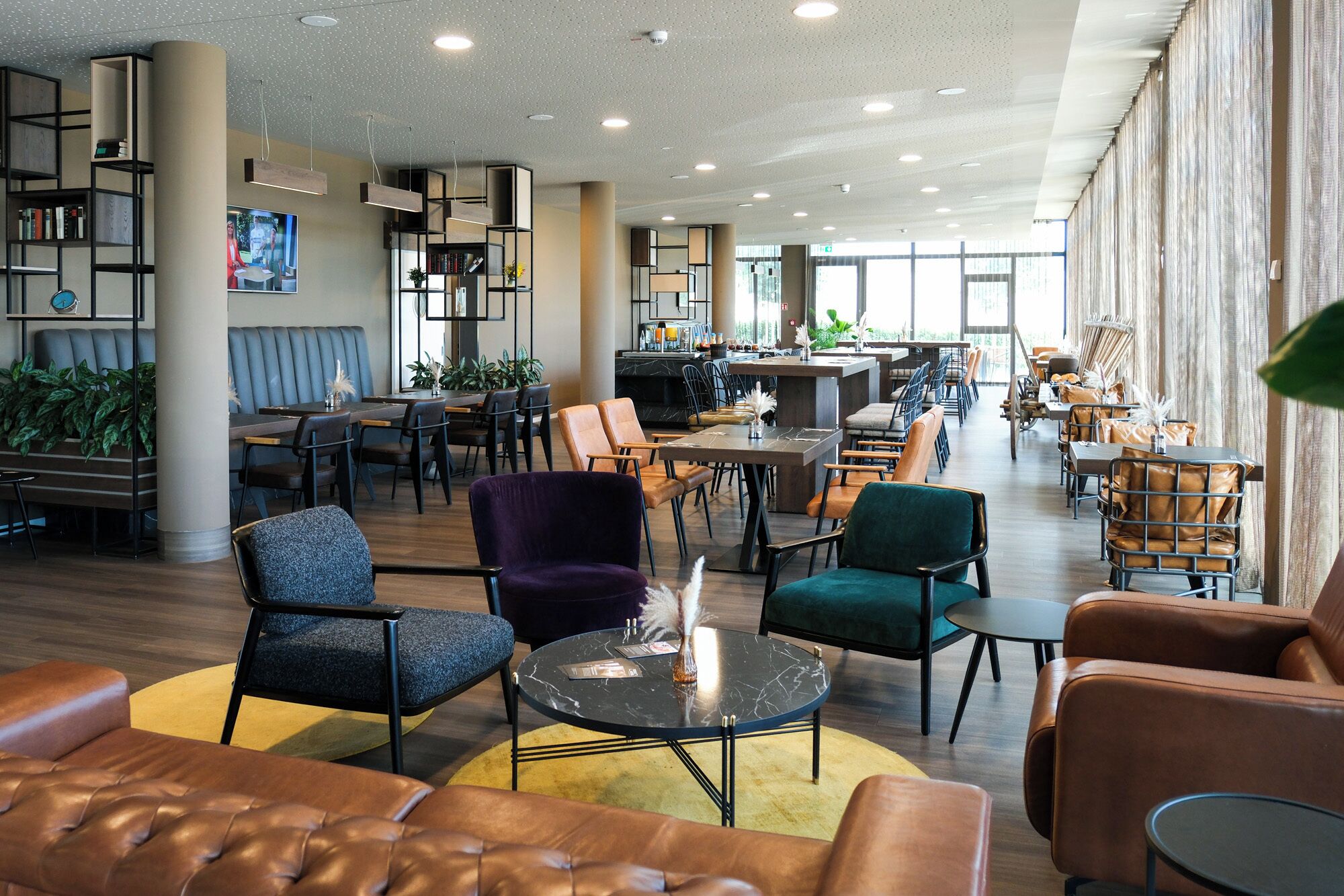 A spacious lobby with leather seating, a bar area, and a dining section.