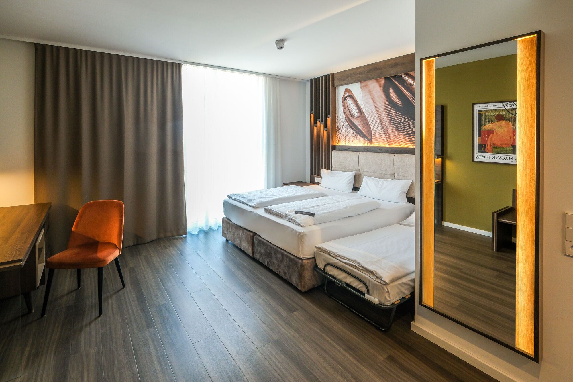 Ein Hotelzimmer mit einem Bett, einem Schreibtisch und einem Stuhl.