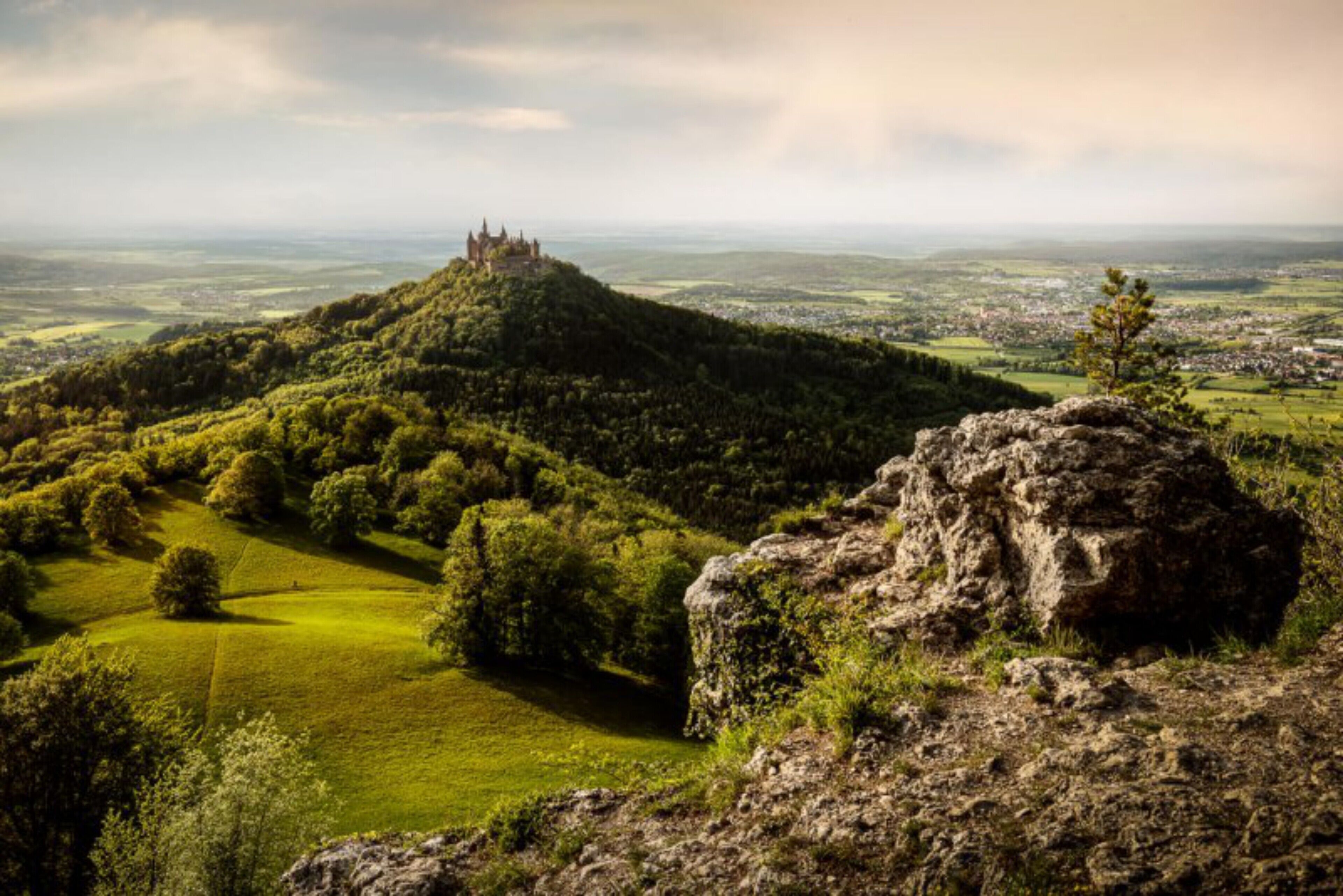 A castle on a hill with a view of a town below.