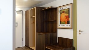 A room with a wooden wardrobe, a bench, and a framed picture on the wall. - Tools Hotel Laichingen/Ulm (Laichingen)