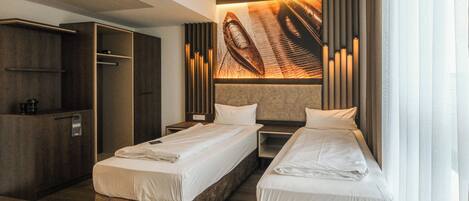 Habitación de hotel con dos camas, un armario e instalación artística única en la pared.