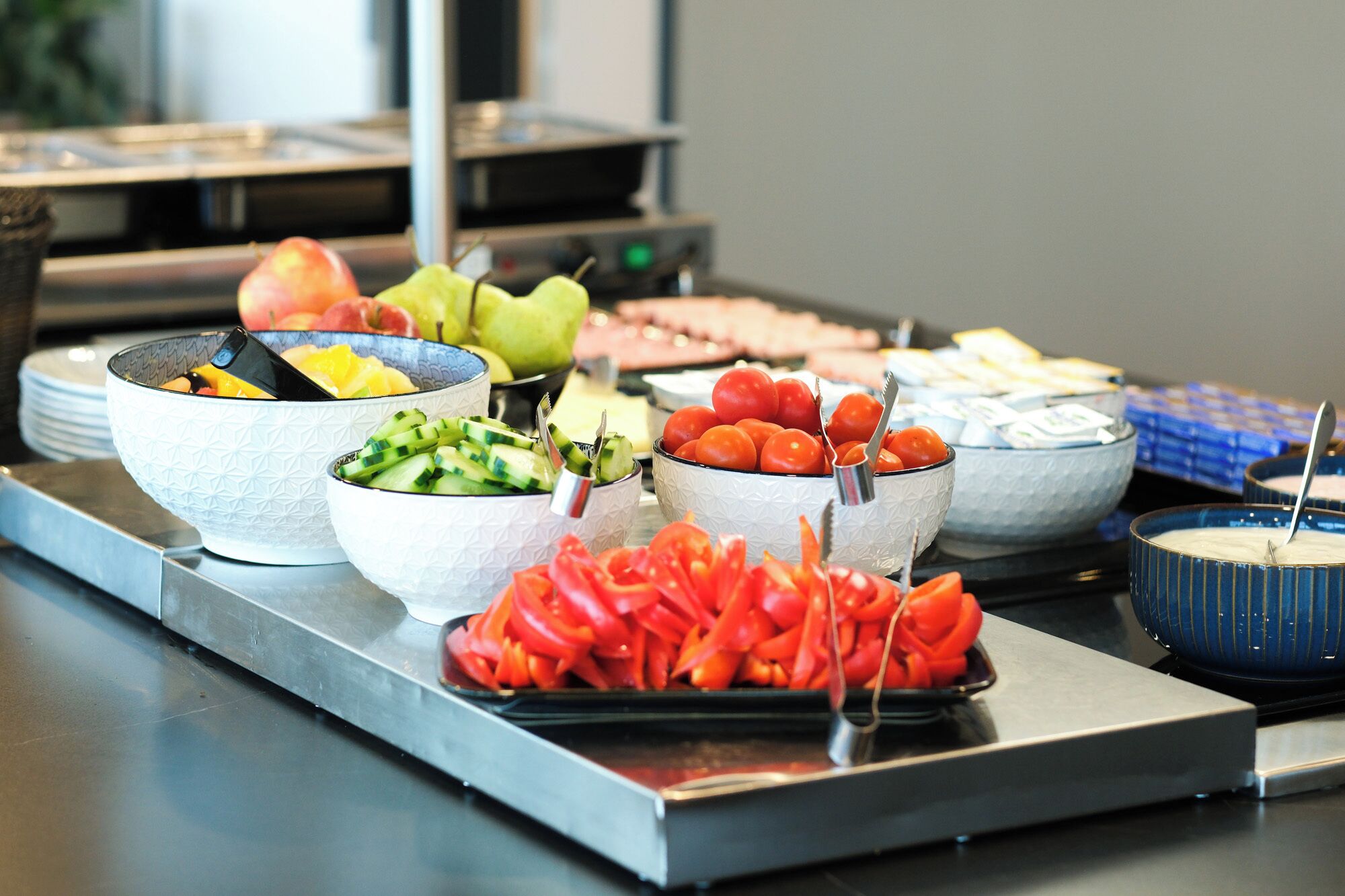 A buffet with various food items including fruits, vegetables, and meats.
