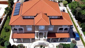 A multi-story building with a red-tiled roof, a central staircase, and a paved driveway. - Little blue fish, cute studio for 2 with pool, pets are welcome (Funtana)