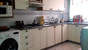 A kitchen with a washing machine, microwave, and cabinets. - Residence Atlas Hivernage 4841 (Marrakech)