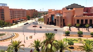 A roundabout with palm trees and a building with a dome and a sign. - Residence Atlas Hivernage 4842 (Marrakech)