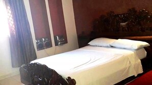A single bed with white bedding, a wooden headboard, and a red carpet. - Residence Atlas Hivernage 4842 (Marrakech)