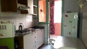 A kitchen with white cabinets, a gas stove, a sink, and a window with a view. - Residence Atlas Hivernage 4842 (Marrakech)