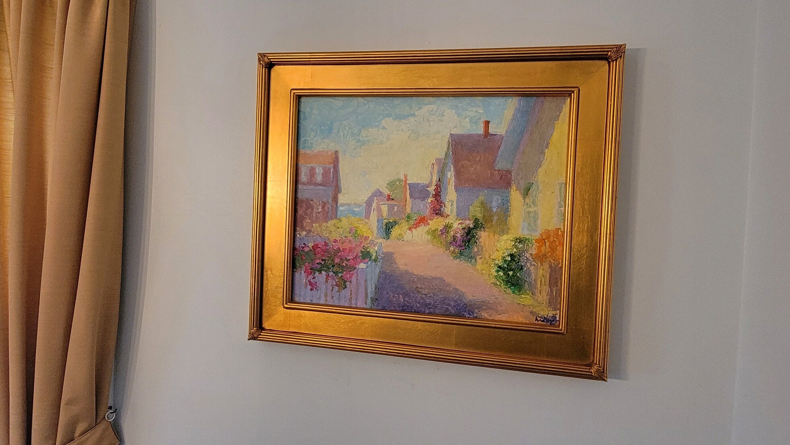 Ein gerahmtes Gemälde, das eine Straßenszene mit Gebäuden und Blumen an einer Wand zeigt.