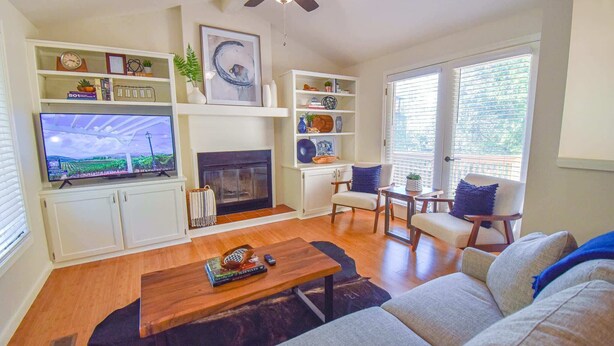 Una sala de estar con chimenea, televisor y zona de estar.