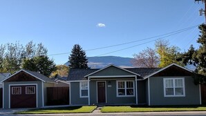 A row of single-story houses with a garage on the left, a front door, and a small porch. - Mama Bear Cottage (Downtown Cody) (Cody)