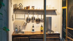 A compact kitchen with wooden cabinets, a sink, and hanging pots. - Hot Tub, Views, Outdoor Oasis (Todd)