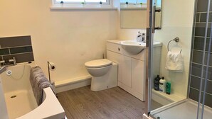 A modern bathroom with a bathtub, toilet, and shower. - Consett Shotley Bridge, Stylish & Modern Two Bedroom Apartment (Consett)