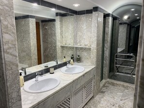 A bathroom with two sinks, a large mirror, and a shower area. - Beautiful Golf and Tennis Apartment in 5 Star Resort, La Manga Club (Cartagena)
