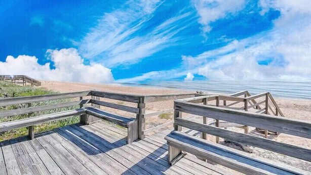 A wooden boardwalk leading to a beach with a clear blue sky and clouds. - 	Modern luxury meets coastal comfort-1200 sq.ft  completely remodeled. Pool (Ormond Beach)