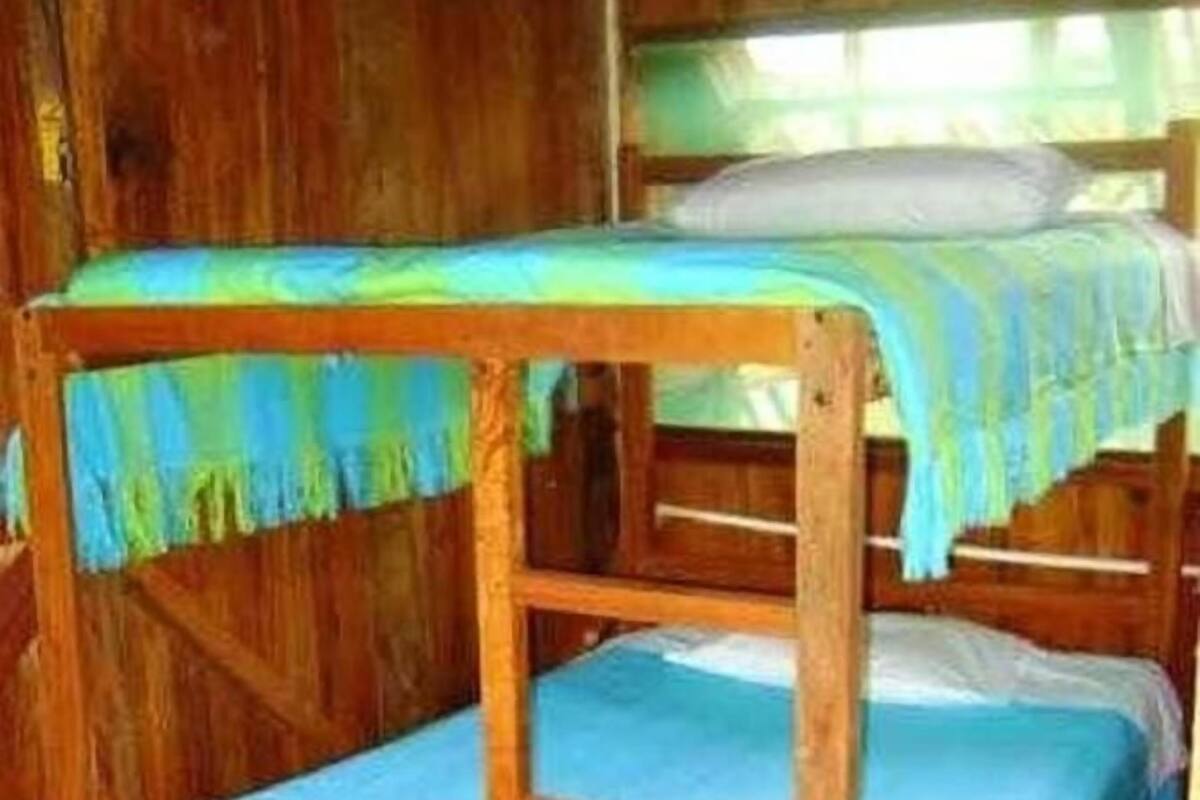 A bunk bed room with a wooden floor and a welcome mat.