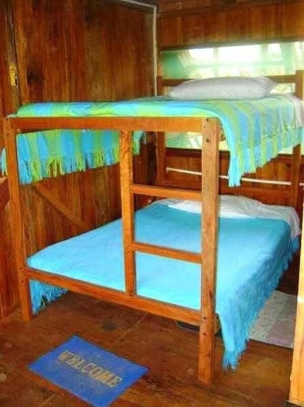 A bunk bed room with a wooden floor and a welcome mat.