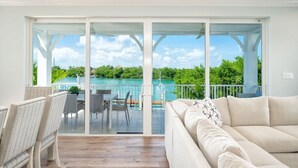 A spacious balcony with a view of a turquoise pool and lush greenery.