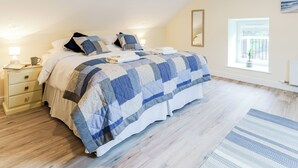 A bedroom with a bed, bedside tables, a window with a view, and a radiator.