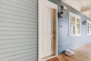 A house with a light blue exterior, a white door, and a number '204' on the wall.