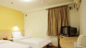 A hotel room with two beds, a small table with a kettle, a television, and a window with striped curtains. - 7 Days Inn Yiyang Center Branch (Yiyang)