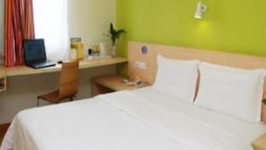 A hotel room with a bed, a desk, a laptop, and a chair. - 7 Days Inn Yiyang Center Branch (Yiyang)
