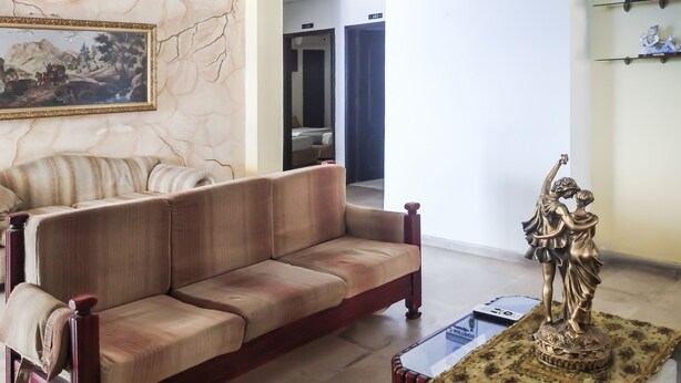 A living room with a sofa, a statue, and a painting on the wall. - Ayenda 1622 Charmin (Santa Marta)