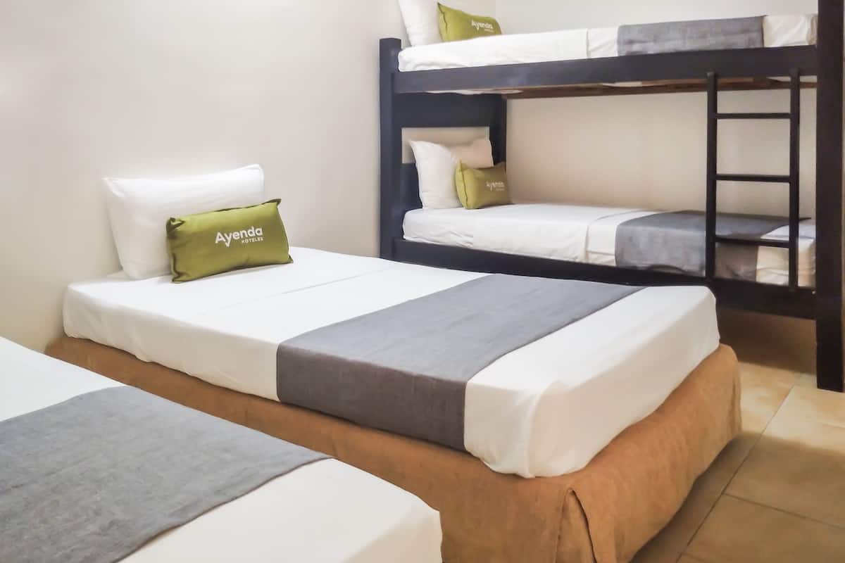 Een slaapkamer met een stapelbed, met twee bedden, elk voorzien van een kussen en dekbed.