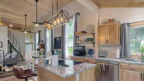 A modern kitchen with granite countertops, stainless steel appliances, and wooden cabinets. - Cozy Historic Schoolhouse w/ Hot Tub + Views (Paola)