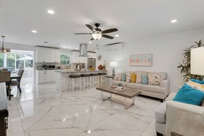 A spacious living area with a kitchen, a ceiling fan, and a dining area. - Heated salt water-pool & spa, walk to local beach, park, boat ramp, restaurants. (North Palm Beach)
